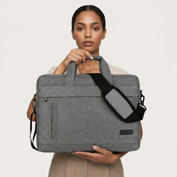 A woman holding a slim laptop shoulder bag in grey