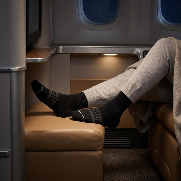 A traveller wearing bamboo compression socks with legs crossed in a plane seat