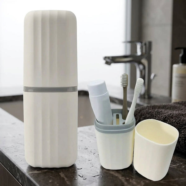 The travel toothbrush holder and rinse cup on a bathroom counter