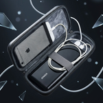 A black hard-shell carrying case shown open, containing a white charging cable and a black rectangular accessory with the brand name 'ANOOK' visible. The case is photographed on a dark abstract background with floating glass-like shards and soft light bokeh.