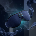 A dark blue sleep mask with a built-in control panel and glowing blue LED lights, floating in a dark room with stylized smoke and flowing fabric elements.