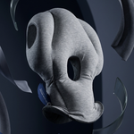 A gray contoured neck pillow with a matching headband, shown floating against a dark navy background with abstract ribbon-like elements.